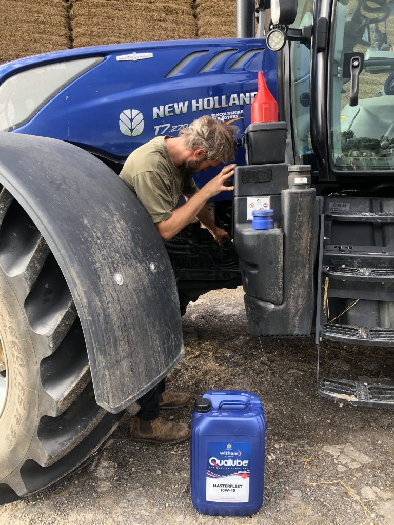 Tractor being topped up with engine oil
