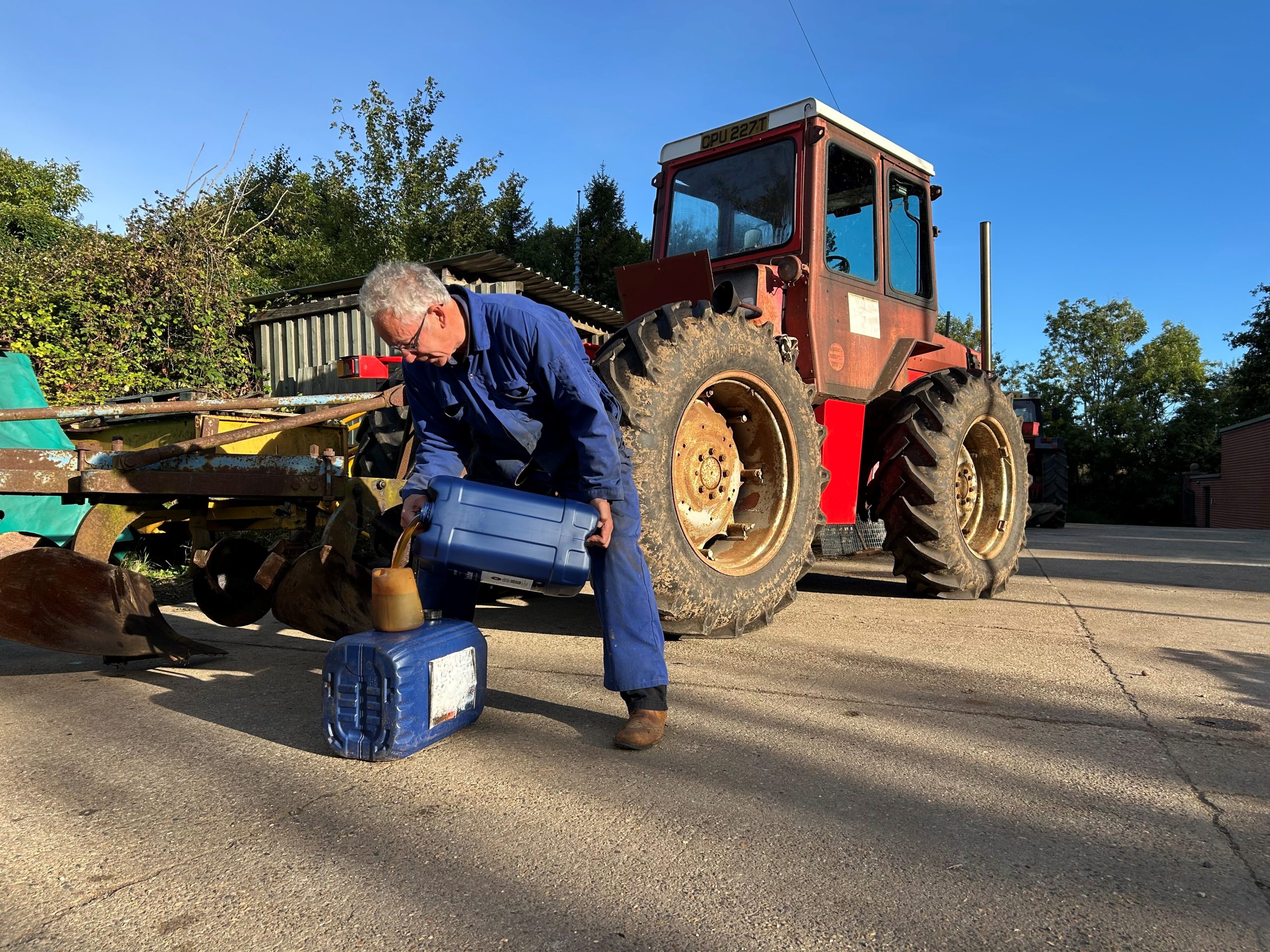 Farmer putting classic oil in tractor